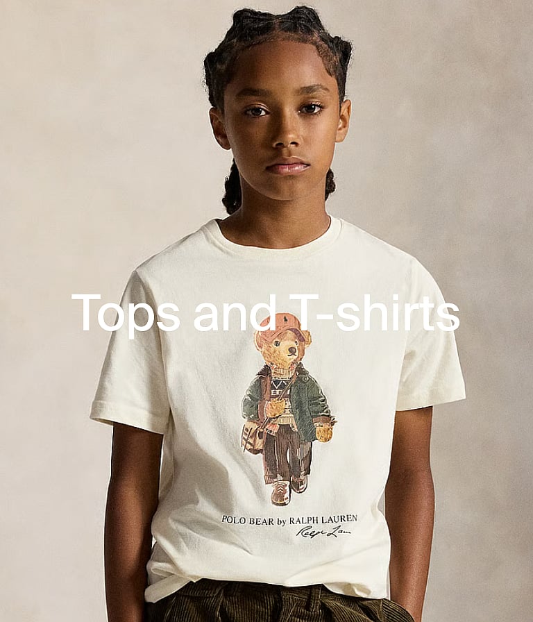 Young boy in a yellow "SAN DIEGO 1984" t-shirt, outdoors with green foliage. "Tops and T-shirts" text overlay.