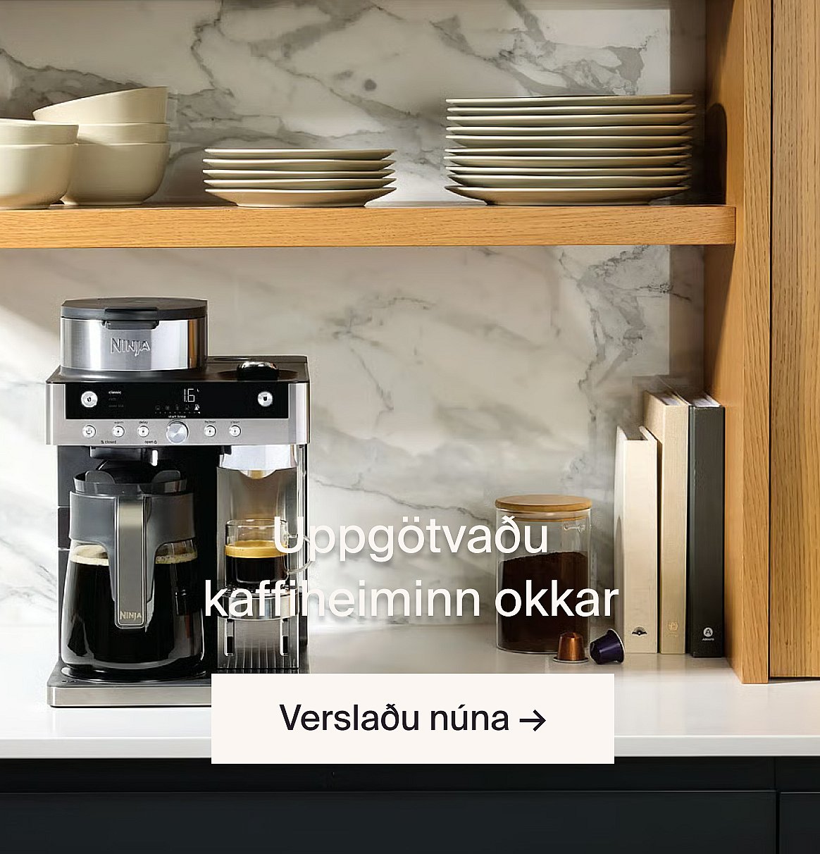 Ninja kaffivél að brugga kaffi á eldhúsbekk. Marmarabaksplata, tréhillur með skálum og diskum.
