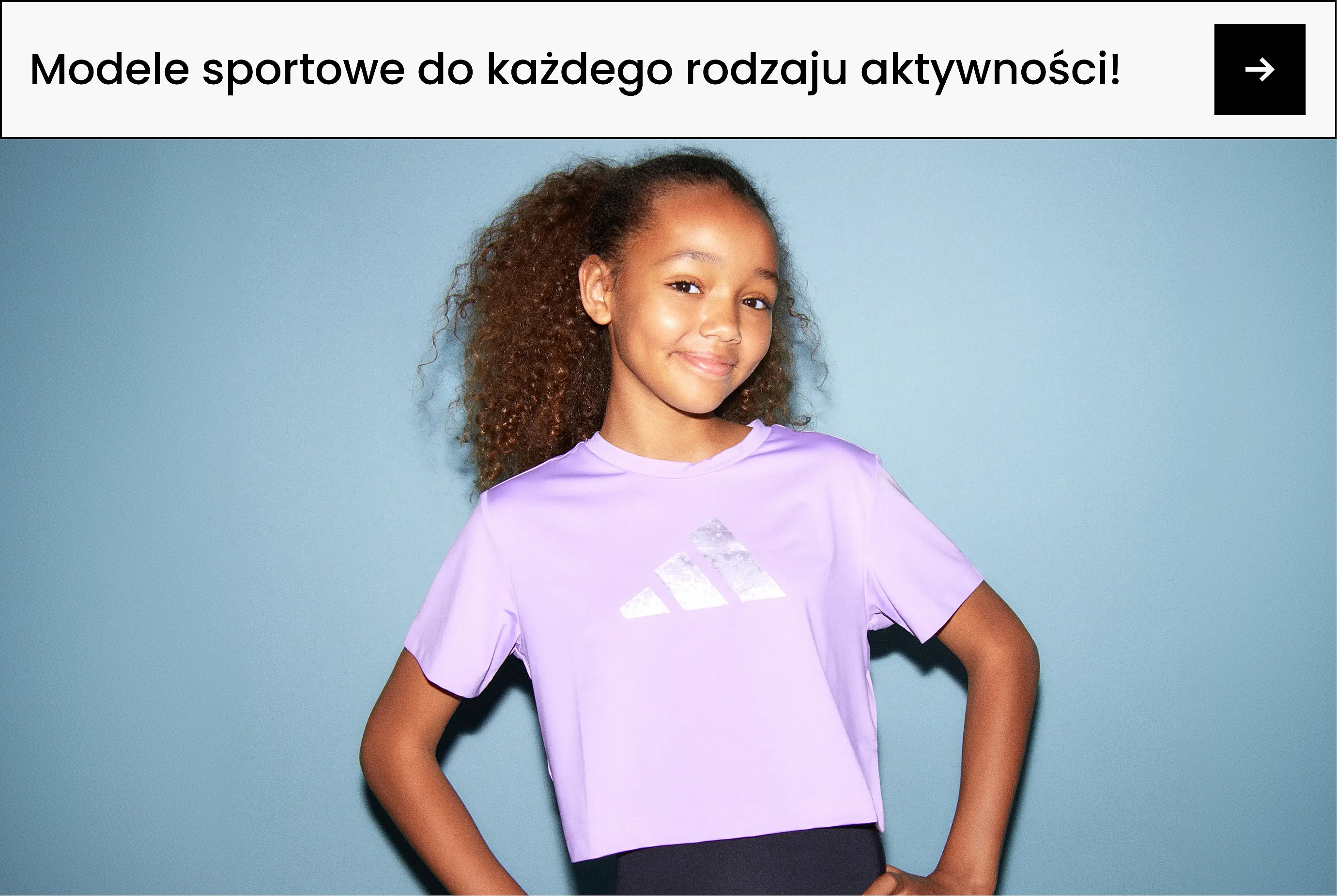 Uśmiechnięta dziewczyna z kręconymi włosami w fioletowej koszulce adidas na jasnoniebieskim tle. Napis: Sport