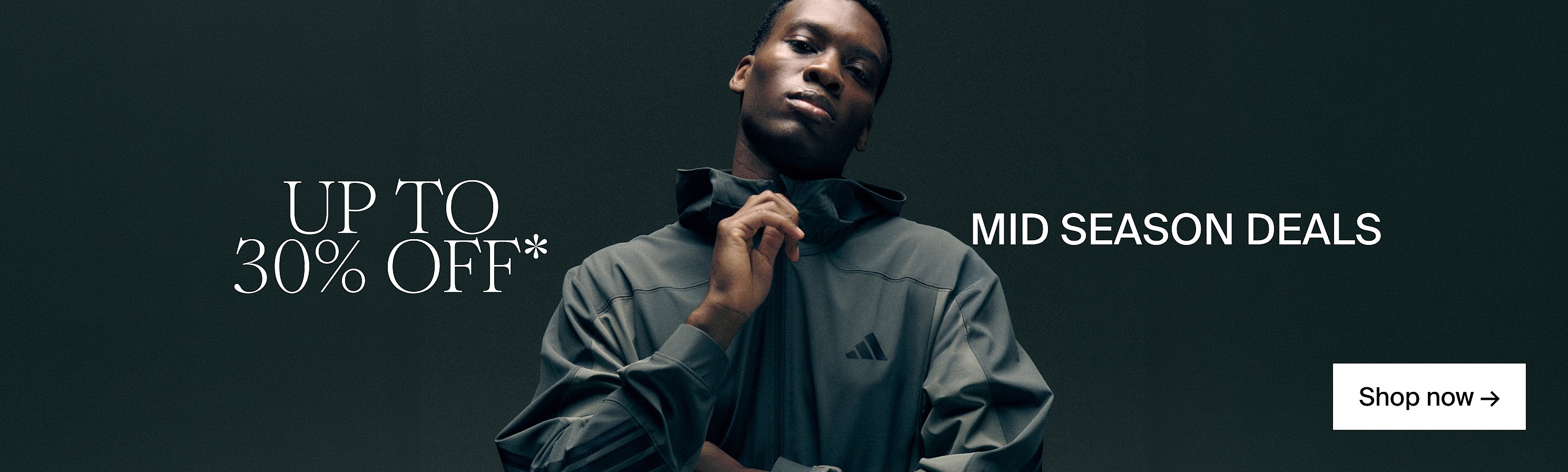 Man in dark hooded jacket on dark background. UP TO 30% OFF*, MID SEASON DEALS, Shop now.