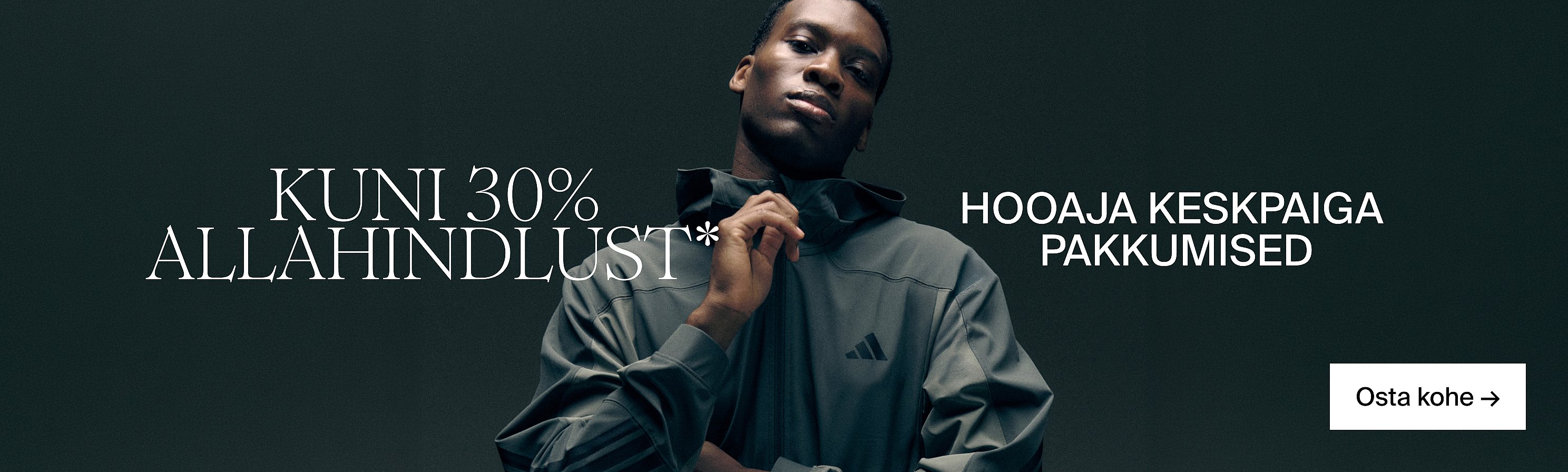 Tumedal taustal seisab mees tumedas kapuutsiga jakis. KUNI 30% SOODUSTUST*, Mid Season Deals, Osta kohe.