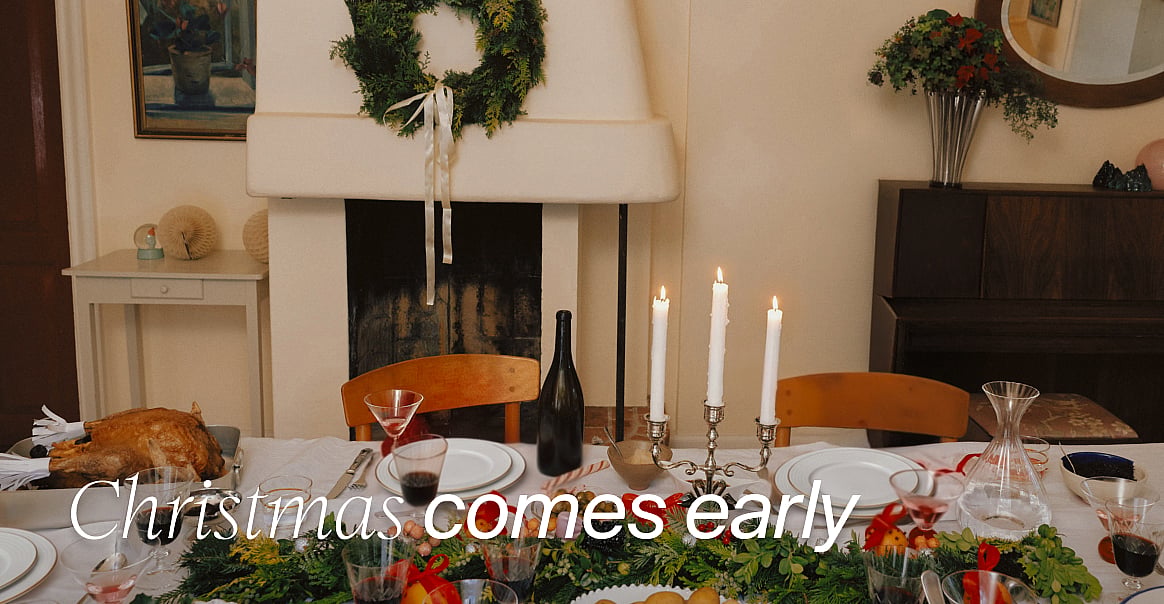 A Christmas dinner table set with a roasted turkey, wine, candles, and garland, in front of a fireplace. Text: "Christmas